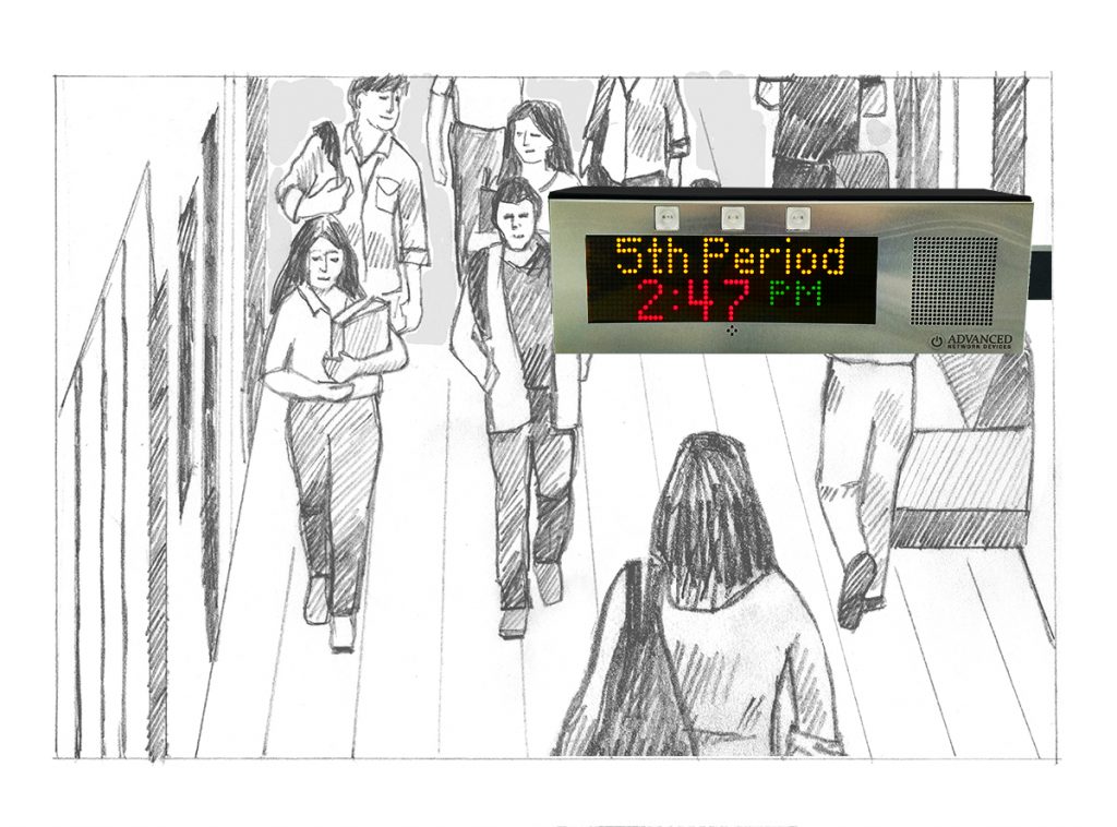 A school hallway with students passing under a double-sided IP display with multi-color text reading